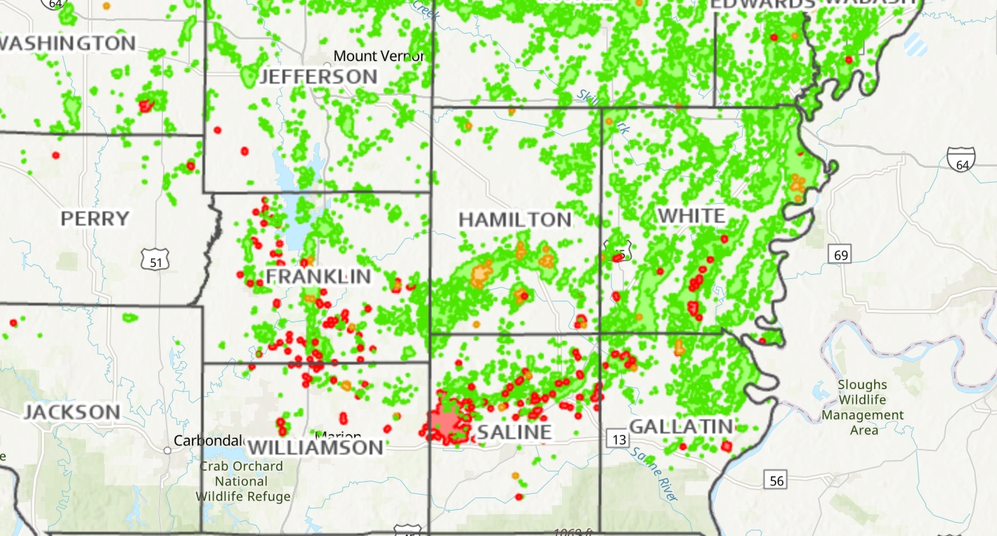 A map of Southern Illinois counties, including Washington, Perry, Jackson, Jefferson, Franklin, Hamilton, White, Williamson, Saline, and Gallatin, displays the locations of oil and gas wells (shown as green dots), injection wells (shown as red dots), and enhanced oil recovery wells (shown as orange dots). The density of wells is particularly high in Franklin, Saline, and White counties. The map indicates the extent of oil and gas development in this region of Illinois. The data is from the Illinois Department of Natural Resources.